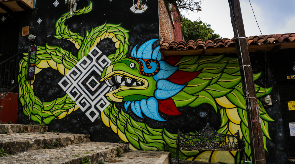 A green dragon painted on a wall along some stone steps.
