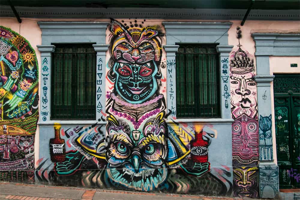 Very colourful graffiti with tribal images and a totem pole