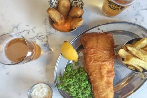 Fish and chips on a plate with peas