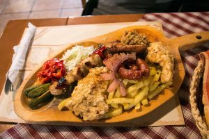 Wooden platter of meat and pickled vegetables