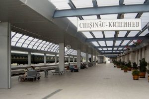 Sign hanging in a tran station reading "Chisinau"