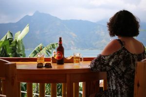 Woman sitting at a wooden bar overlooking a lake