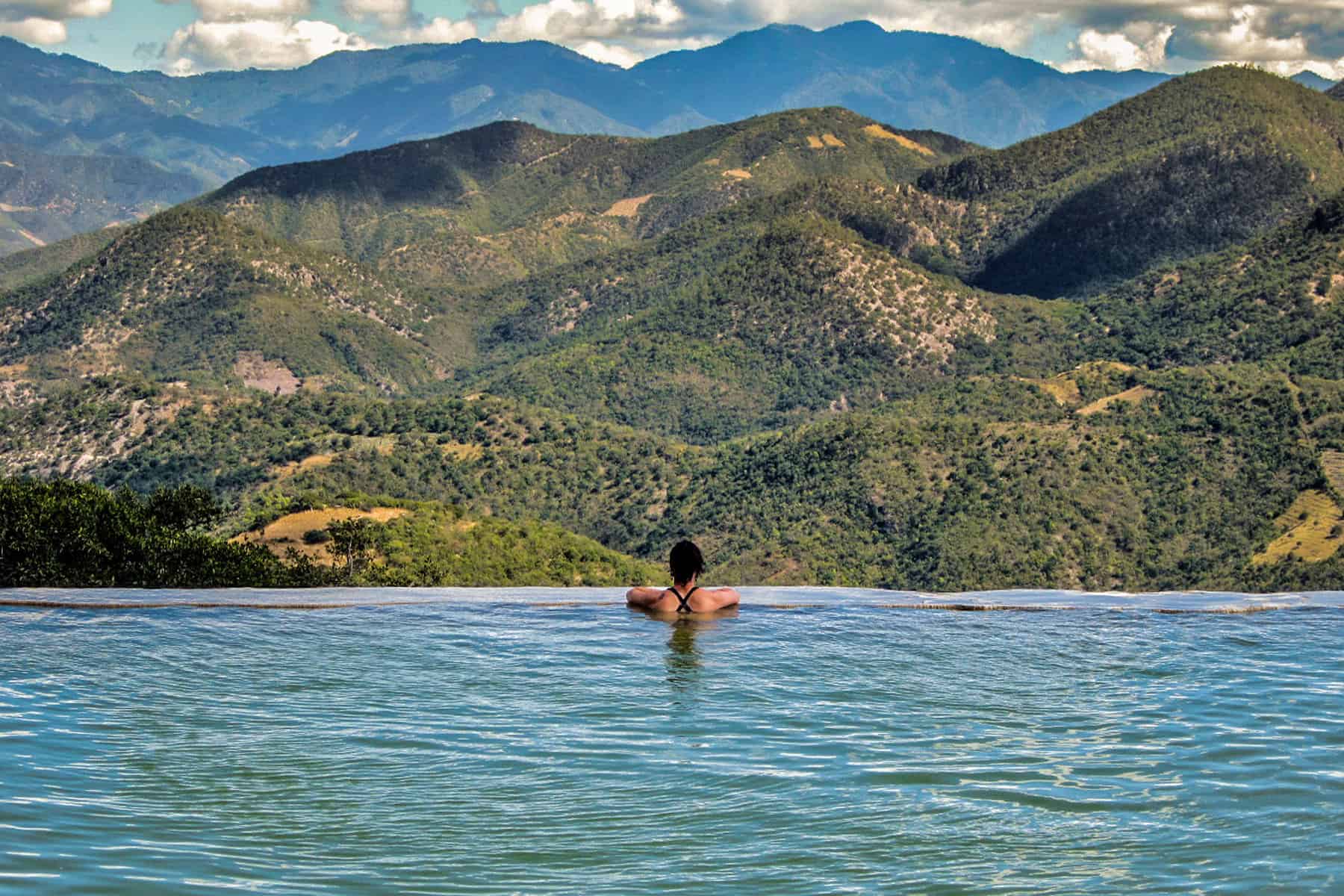 Girl in water overlooking a large valley at Hierve el Agua Mexico