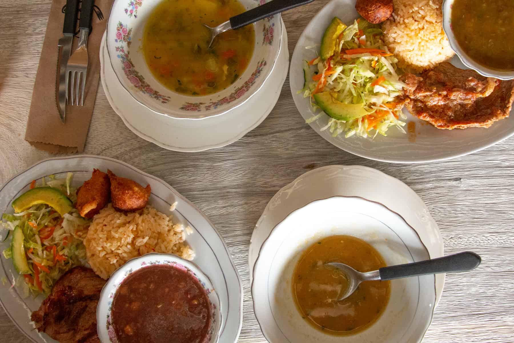 Plates of soup, meat and salad