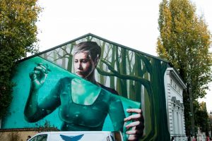 Green street art of a girl on a wall