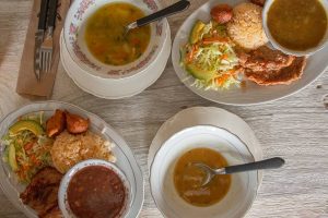 Multiple plates of food and bowls of soup