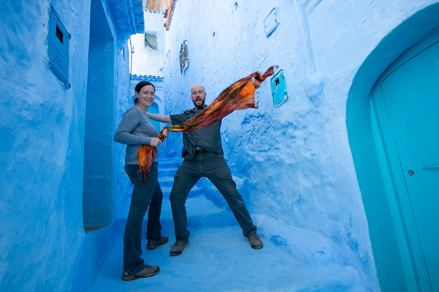 Two people standing in an alley that is completely painted blue.