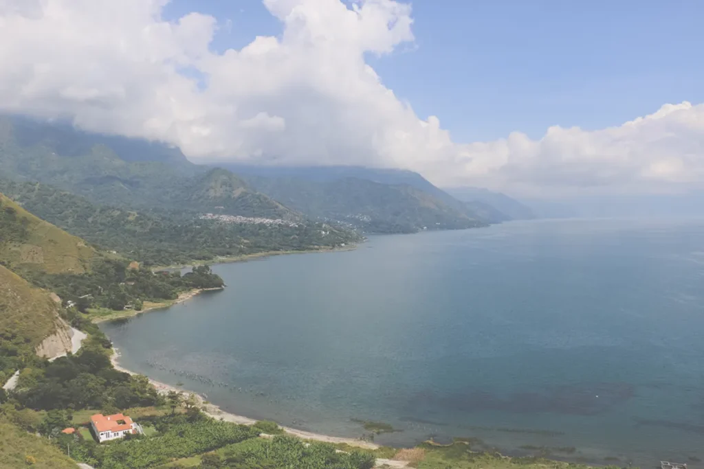 Looking down at a large lake surrounded by green hills.